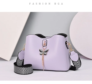Detail of lavender purple bow shell bag with striped wide strap and gold hardware