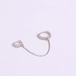 Detail of silver double hoop earrings with cubic zirconia and connecting chain link