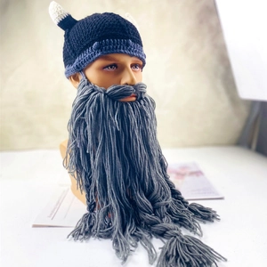 Detail of creative knit Viking helmet hat with white horns and long grey braided beard