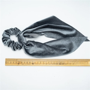 Gray velvet scrunchie with long ribbons shown on a white background with a wooden ruler