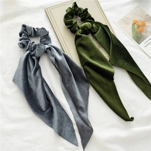Detail of velvet scrunchies with long ribbons in grey-blue and dark green colors