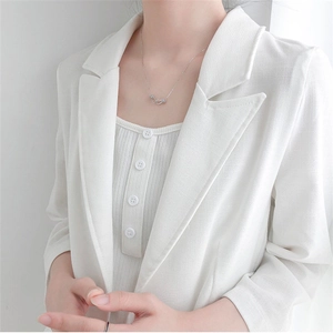 Close-up of model wearing 925 silver interlocking ring necklace with white blazer