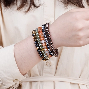 Close-up of faceted crystal glass beads bracelet with glossy orange and black stones