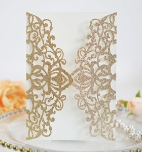 Macro detail of laser-cut wedding invitation cover with gold glitter baroque pattern