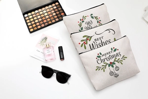 Detailed flat lay of three Christmas theme cotton linen makeup bags with festive prints