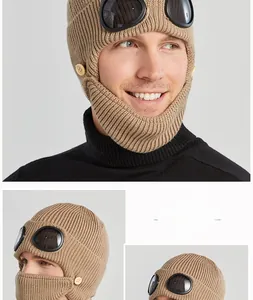 Detail of khaki cable knit pilot hat featuring built-in goggles and mask for winter warmth