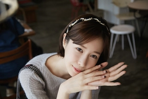 Close-up of a slim black pearl headband with rhinestones worn by a model in a cafe