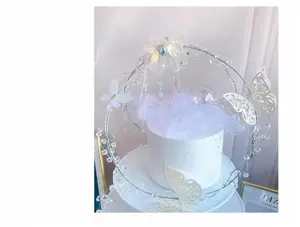 Elegant fairy style iron art cake topper with pearls, butterflies, and tulle decoration.