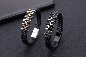Macro detail of men's braided black leather bracelet with steel magnetic clasp