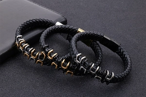Close-up of men's braided leather bracelets with gold, silver and black metal buckles