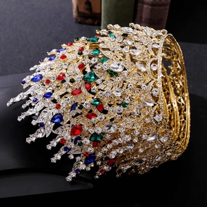 Detailed side view of baroque gold leaf crown featuring vibrant red and blue crystals