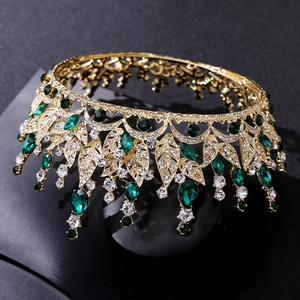 Detail of golden leaf crown featuring green crystals and sparkling rhinestones