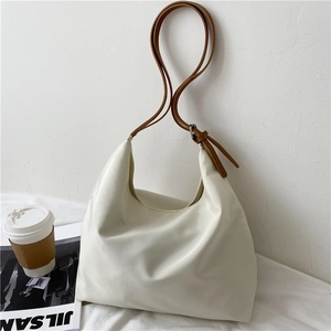 Close-up of cream white hobo bag with brown leather strap and high-density fabric texture
