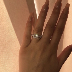 Close-up of zircon wedding ring with four-prong setting and pavé diamonds on the band