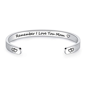 Detail of silver stainless steel cuff bracelet with heart symbols and mom engraving