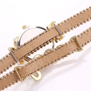 Detailed close-up of light brown leather and golden beaded chain multilayer watch strap