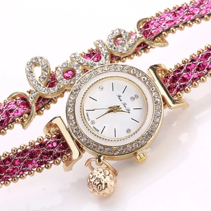 Detail of rhinestone LOVE charm and pink glitter strap on gold luxury bracelet watch