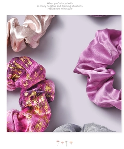 Close-up of velvet and satin scrunchies in champagne, purple and gold foil accents