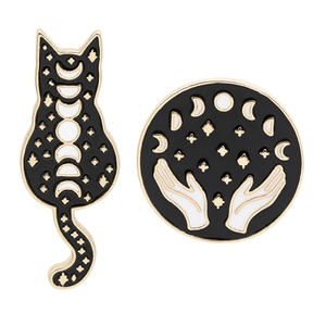 Black enamel pins set featuring moon phase cat and hands holding stars on white background