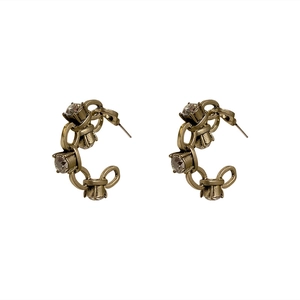 Exaggerated C-shaped hoop earrings in vintage gold with interlocking rings and crystals