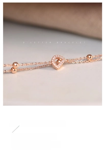 Macro detail of S925 sterling silver letter D pendant in rose gold with pave zircons