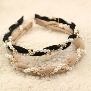 Detail of twisted fabric headband with pearls and rhinestones on soft faux fur