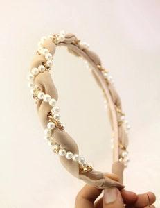 Detail of woven fabric headband featuring elegant white pearls and sparkling rhinestones