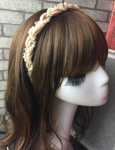 Detail of champagne satin twisted headband featuring white faux pearls and tiny crystals