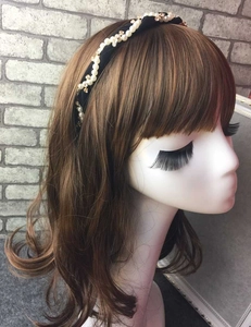 Detail of black fabric headband with faux pearls and rhinestones on a mannequin