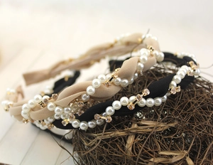 Detail of twisted fabric headband featuring faux pearls and sparkling rhinestones