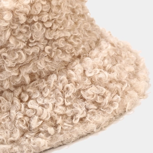 Makroaufnahme der beigen Teddy-Fleece-Textur eines warmen Winter-Anglerhutes