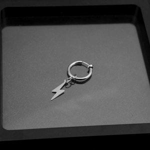 Close-up of a polished stainless steel lightning bolt pendant on a thin hoop earring