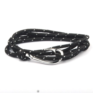 Close-up of nautical multi-layer woven rope bracelet with polished silver fish hook clasp