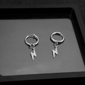 Detailed view of silver stainless steel lightning bolt earrings on a black tray