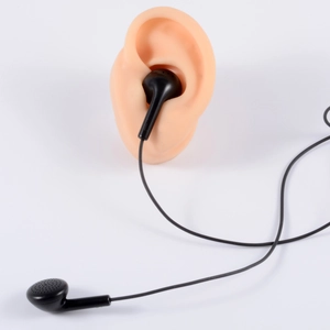 Black wired in-ear earphones displayed on realistic silicone ear model for fit showing