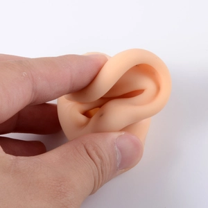 Flesh-colored silicone ear model for jewelry display showing high flexibility and softness