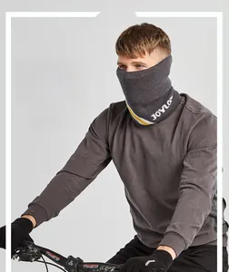 Detail of dark gray winter cycling neck gaiter with logo and matching cycling gloves