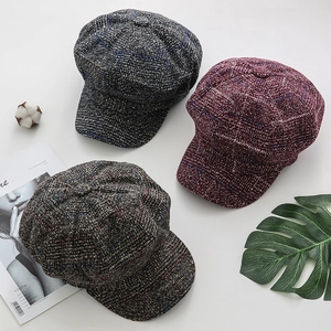 Close-up of wool octagonal hats in grey, wine red and brown with classic plaid texture