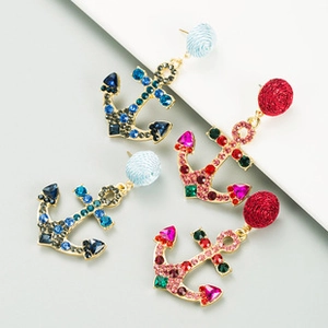 Detail of anchor earrings featuring woven ball studs and colorful crystal rhinestones