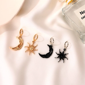 Minimalist sun and moon asymmetric earrings in gold and black hollow design