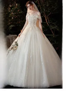 Détail des broderies de feuilles argentées et paillettes sur une robe de mariée ivoire
