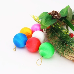 Assorted silk thread wrapped Christmas ball ornaments with pine needle wreath on white