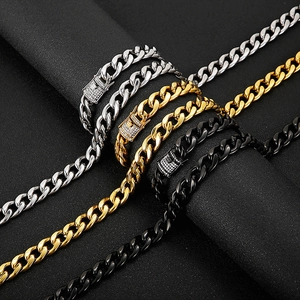 Close-up of cuban link chain bracelets in gold, silver, and black with pavé diamond clasps