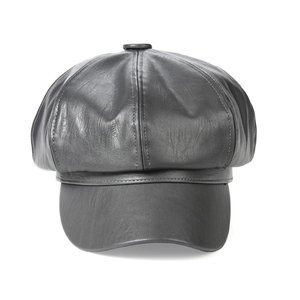 Detailed view of the black leather texture and stitched panels on the octagonal newsboy hat