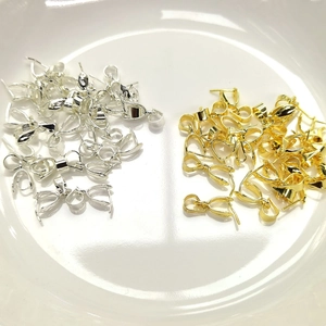 Macro shot of 14k gold-filled and silver bail pendant connectors for DIY jewelry