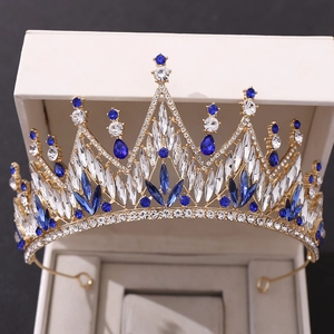 Close-up of gold bridal crown with blue and white crystals in a premium gift box