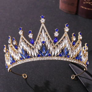 Detailed view of luxury gold crown with blue teardrop crystals and white rhinestones