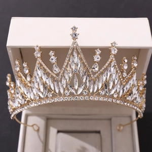 Close-up of a white crystal bridal crown nestled in a beige jewelry box with golden base