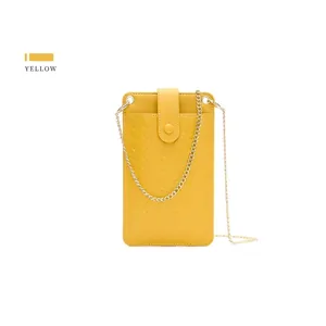 Detail of yellow woven texture phone bag with elegant gold chain strap and snap closure