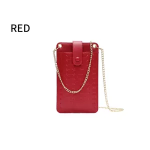 Detail of red quilted mini crossbody bag with woven texture and gold chain strap